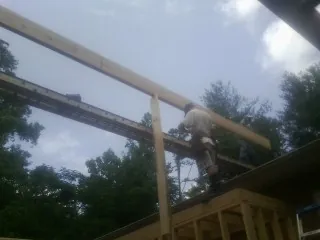 Carpenter setting a ridge beam over a new addition frame — Ice Dam Removal by Roofing Brothers in Hansen