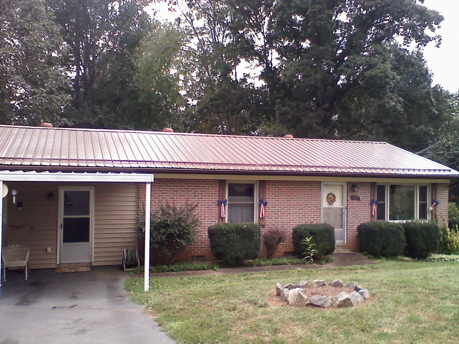 Bronze metal roof and carport on a brick ranch home — Roof Repair work by our crew in Hansen